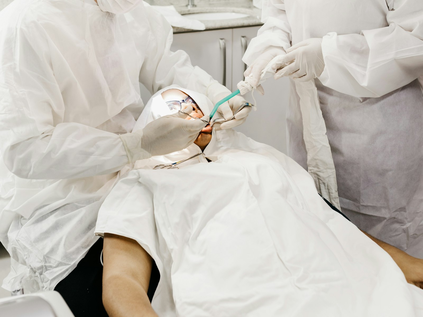 Dentistas con protección realizando un tratamiento a un paciente